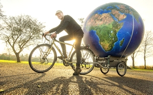 Dirk Kuiken fietste naar Den Haag met een grote wereldbol achter zijn fiets. FOTO MARCEL VAN KAMMEN